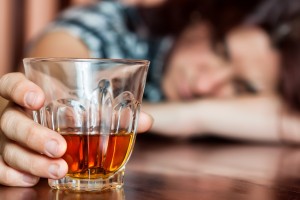 Asleep drunk woman holding an alcoholic drink
